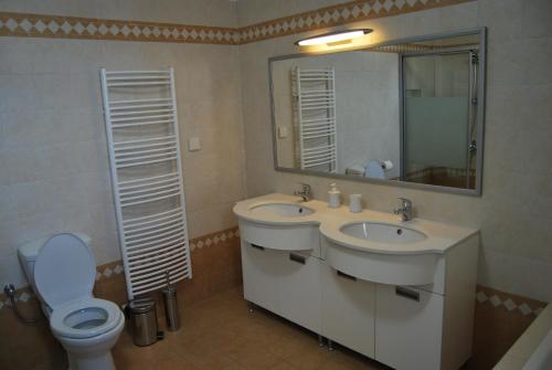 a bathroom with two sinks and a toilet and a mirror at BAY VIEW HOUSE in Megas Gialos - Nites