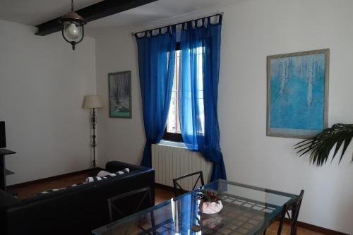 a living room with blue curtains and a glass table at Agriturismo Molino Nuovo in Castel San Pietro Terme