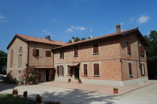 a large red brick building with a courtyard at Agriturismo Molino Nuovo in Castel San Pietro Terme