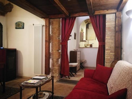 a living room with a red couch and a table at Appartamento La Loggia in Orvieto