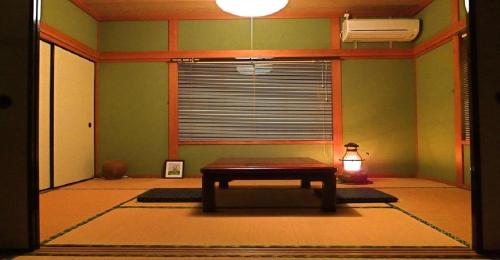 um quarto com uma mesa em frente a uma janela em Private Twin Room - Aoshima Guesthouse Hooju - Vacation STAY 6392 em Miyazaki