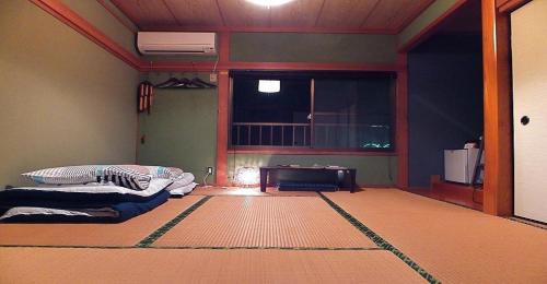 uma sala de estar com duas camas e uma janela em Private Twin Room - Aoshima Guesthouse Hooju - Vacation STAY 6392 em Miyazaki