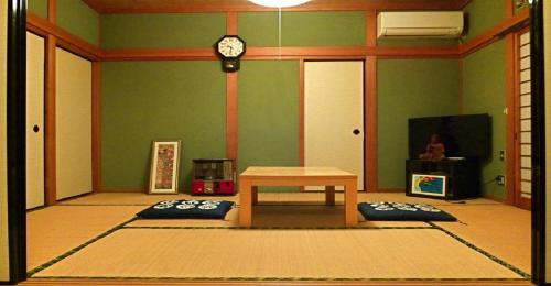 um quarto com uma mesa e um relógio na parede em 8Bed Dormitory Room - Aoshima Guesthouse Hooju - Vacation STAY 6198 em Miyazaki