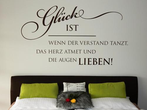 a bedroom with a bed with a sign on the wall at WEITBLICK "entspannen - wohlfühlen - aktiv erholen" in Elzach