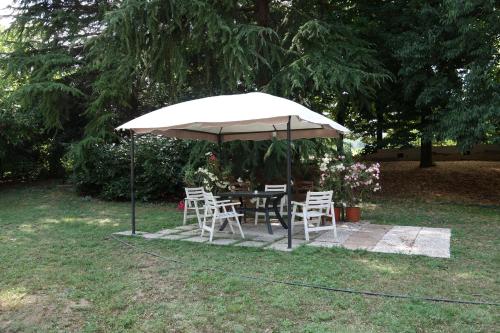 a table and chairs under an umbrella in a yard at Agriturismo Molino Nuovo in Castel San Pietro Terme