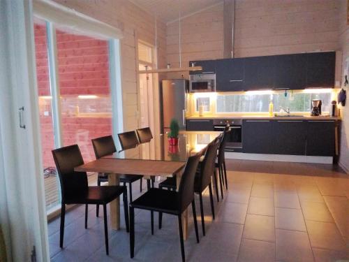 comedor con mesa y sillas en la cocina en Nestorinranta Villa, en Lintusalo
