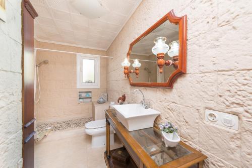 a bathroom with a sink and a toilet and a mirror at Casas Mari y Pili para 12 personas a unos 200 m de la playa in Portocolom