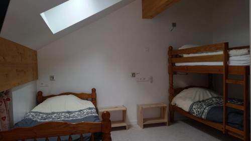 a bedroom with two bunk beds and a skylight at Hotel Restaurant LE YETI in Les Rousses