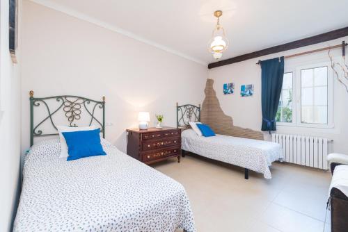 a bedroom with two beds and a chair at Casas Mari y Pili para 12 personas a unos 200 m de la playa in Portocolom