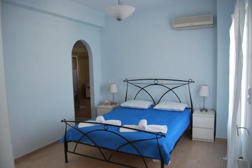 a blue bedroom with a bed with blue sheets and towels at BAY VIEW HOUSE in Megas Gialos - Nites