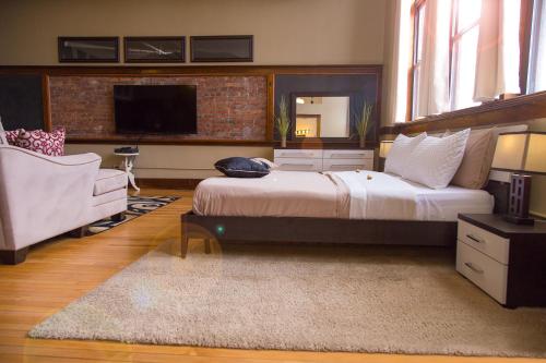 a bedroom with a bed and a tv and a couch at School 31 Lofts in Rochester
