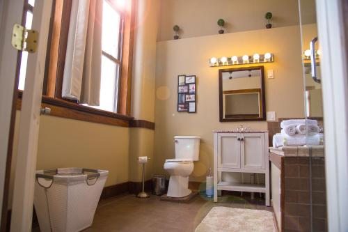 a bathroom with a toilet and a sink and a mirror at School 31 Lofts in Rochester