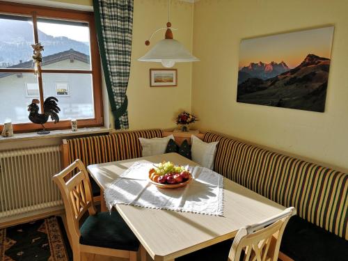 a dining room table with a bowl of fruit on it at Vornbichlhof in Fieberbrunn