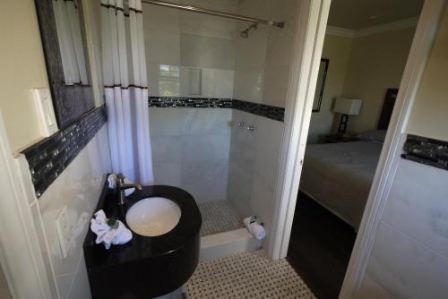 a bathroom with a toilet, sink, and shower stall at Trylon Hotel - Hollywood in Los Angeles