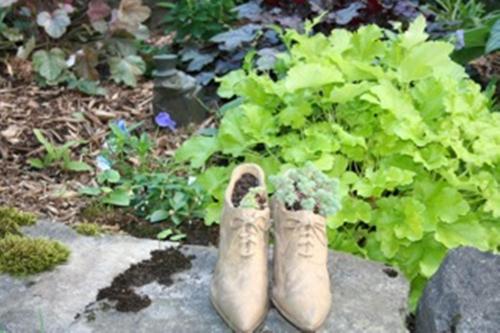 a pair of boots sitting next to a green plant at Burley's Executive Garden Suite in Peterborough