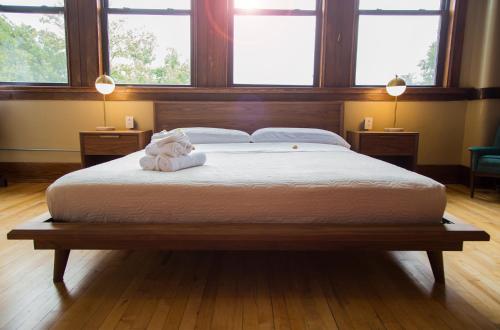 a large bed with a teddy bear laying on it at School 31 Lofts in Rochester