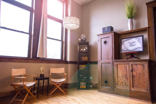 a room with chairs and a table and a cabinet at School 31 Lofts in Rochester