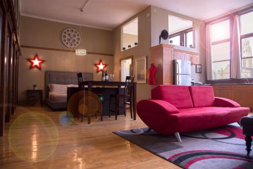 a living room with a red chair and a table at School 31 Lofts in Rochester