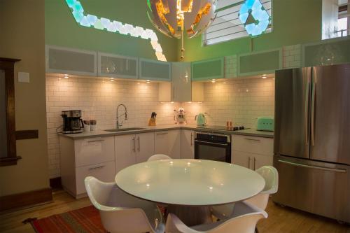 a kitchen with a white table and a refrigerator at School 31 Lofts in Rochester
