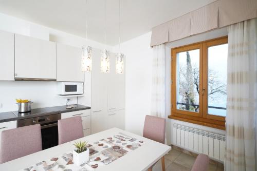 a kitchen with a white table and chairs and a window at Villa delle Querce in Tremosine Sul Garda
