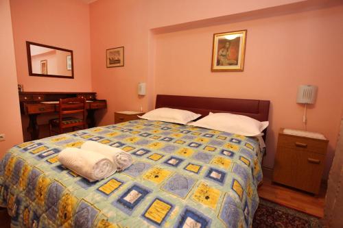 une chambre avec un lit recouvert d'une couette bleue et jaune dans l'établissement Split Apartments Peric, à Split