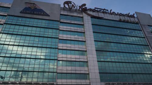a building with a sign on the top of it at Palm Tree Condos across NAIA3 by Beth in Manila