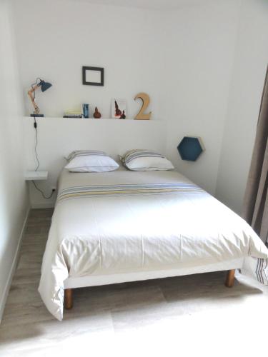 sypialnia z dużym białym łóżkiem w pokoju w obiekcie L'Eau Reine w mieście Saumur