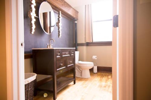 a bathroom with a sink and a toilet and a mirror at School 31 Lofts in Rochester
