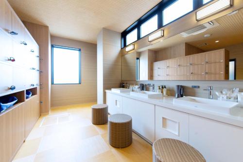 大阪的住宿－HOTEL HILLARYS Shinsaibashi，浴室设有2个水槽和2个凳子