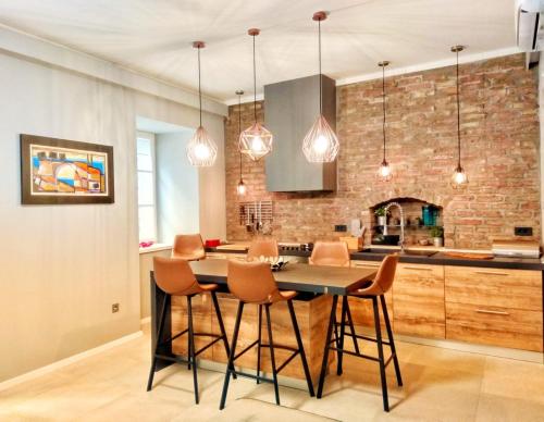 a kitchen with a table and chairs and a brick wall at St. Mark's Boutique Apartment Zagreb in Zagreb