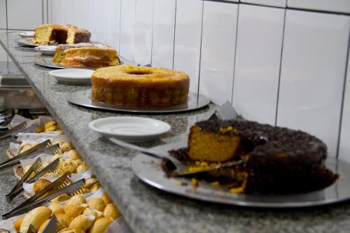 a table with several different types of cakes and pastries at Presidente Hotel in Passos