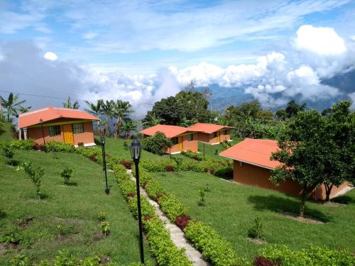 a row of houses in a field of grass at Paraíso Tropical - Hotel Campestre in Aguadas