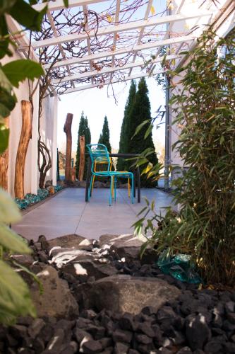 a blue chair sitting on a patio in a garden at Art & Nature Apartments in der Nähe FFM-Messe in Bad Vilbel
