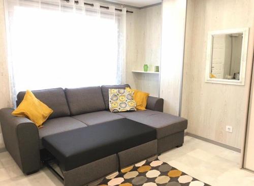 プラヤ・デ・ファニャベにあるPueblo Canario Loft In Las Americasのリビングルーム(黄色の枕とグレーのソファ付)