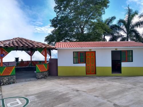 a small white house with a red roof at Paraíso Tropical - Hotel Campestre in Aguadas
