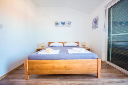 1 dormitorio con cama y ventana grande en Apartments and Rooms Skalinada, en Murter