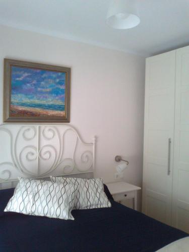 ネルハにあるApartamento Azulのベッドルーム1室(ベッド1台付)が備わります。壁には絵画が飾られています。