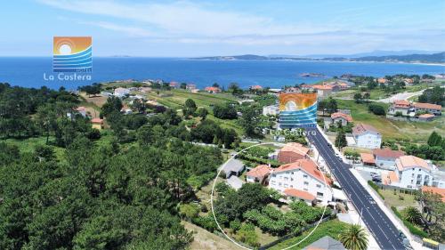 - une vue aérienne sur la ville et l'océan dans l'établissement Hotel La Costera, à A Lanzada