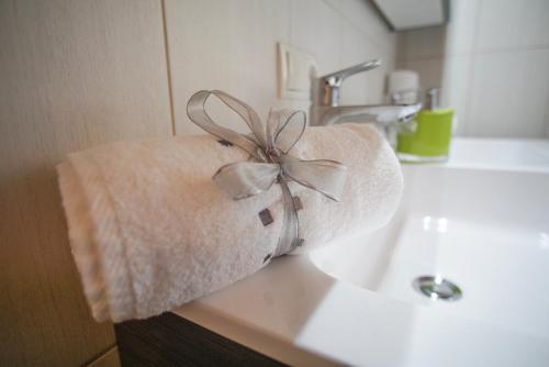 a towel with a ribbon sitting on a bathroom sink at Apart Waldblick in Oetz