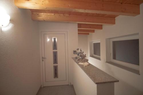 a hallway with white walls and wooden beams at Apart Waldblick in Oetz