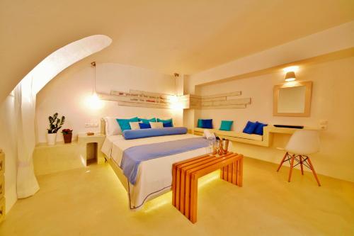 a bedroom with a large bed and a table at Chroma Suites in Oia