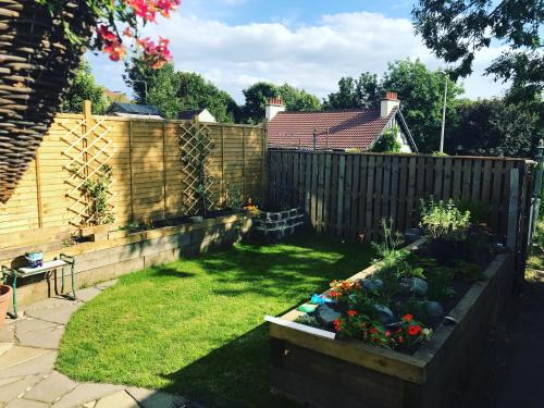 a backyard with a fence and a garden with flowers at A Wee Cottage In Dunfermline in Dunfermline