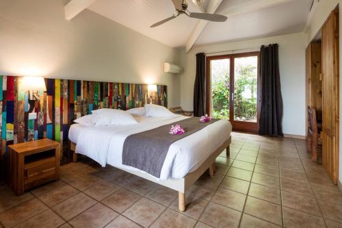 - une chambre avec un grand lit blanc orné de fleurs dans l'établissement Le Rayon Vert, à Deshaies