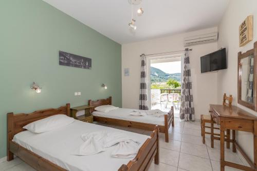 a hotel room with two beds and a window at Yiota Studios in Alykes