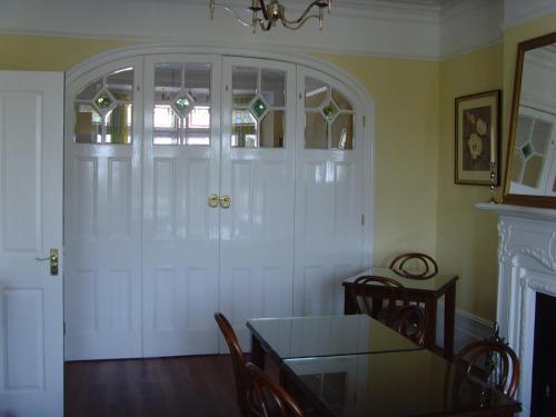 a dining room with a table and a white door at Breakers Bed and Breakfast in Eastbourne