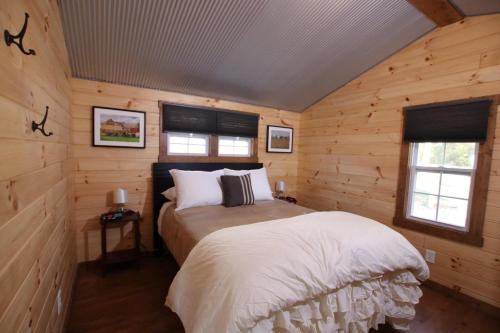 1 dormitorio con 1 cama en una cabaña de madera en The Cayo Cabin, Millersburg Ohio, en Millersburg
