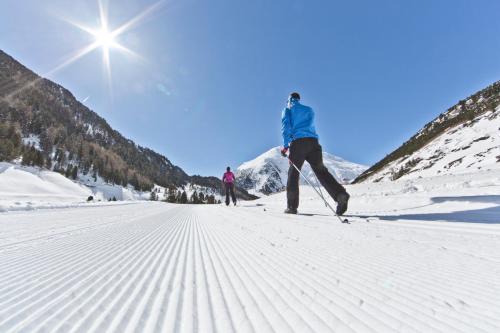 two people cross country skiing on a snow covered mountain at Apart Andrea in Längenfeld