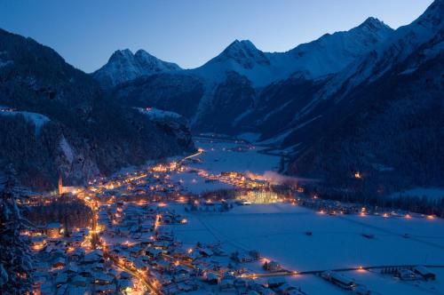 a view of a town in the mountains at night at Apart Andrea in Längenfeld