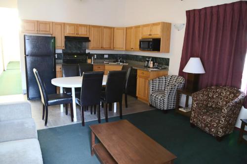 a kitchen and living room with a table and chairs at Slumber Lodge in Penticton