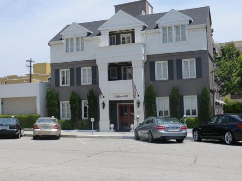 a large building with cars parked in a parking lot at Maison 140 Beverly Hills in Los Angeles